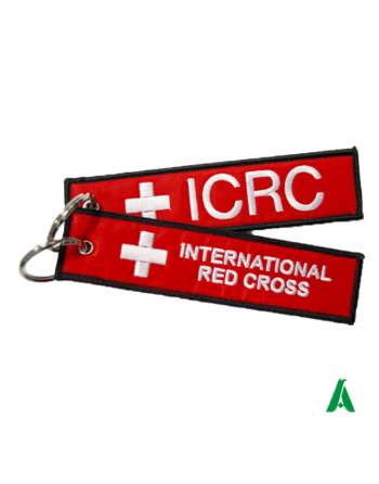 Portachiavi in tessuto rosso acceso con ricami scritte croce rossa internazionale, stile remove before flight